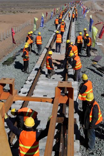 Chinese construction workers lay rails for the Ha'e (Hami-Ejina) Railway in Hami, northwest China's Xinjiang Uygur Autonomous Region, 5 September 2015.No Use China. No Use France.