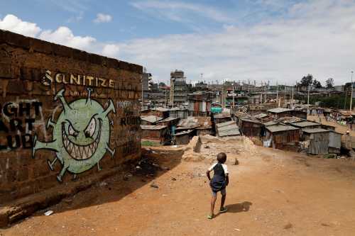 A boy walks in front of a graffiti promoting the fight against the coronavirus disease (COVID-19) in the Mathare slums of Nairobi, Kenya, May 22, 2020. REUTERS/Baz Ratner TPX IMAGES OF THE DAY