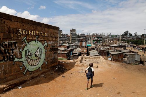 A boy walks in front of a graffiti promoting the fight against the coronavirus disease (COVID-19) in the Mathare slums of Nairobi, Kenya, May 22, 2020. REUTERS/Baz Ratner TPX IMAGES OF THE DAY