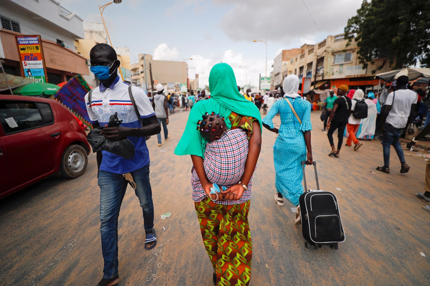 A woman carries her protective mask in her hands as hundreds of thousands of the Senegalese Mouride Brotherhood pilgrims gather for the annual Grand Magal festival, as the global spread of the coronavirus disease (COVID-19) continues, in the holy city of Touba, Senegal October 5, 2020. Picture taken October 5, 2020. REUTERS/Zohra Bensemra