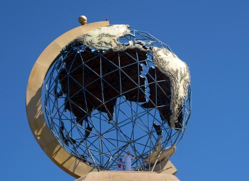 Boys stand underneath a globe representing the earth, set on top of a roundabout during Friday prayers in the northern industrial town of Sohar in Oman March 4, 2011. Prayers were held in honour of those who lost their lives during the unrest in Oman of protests demanding jobs and political reforms. REUTERS/Jumana El-Heloueh (OMAN - Tags: CIVIL UNREST POLITICS RELIGION)