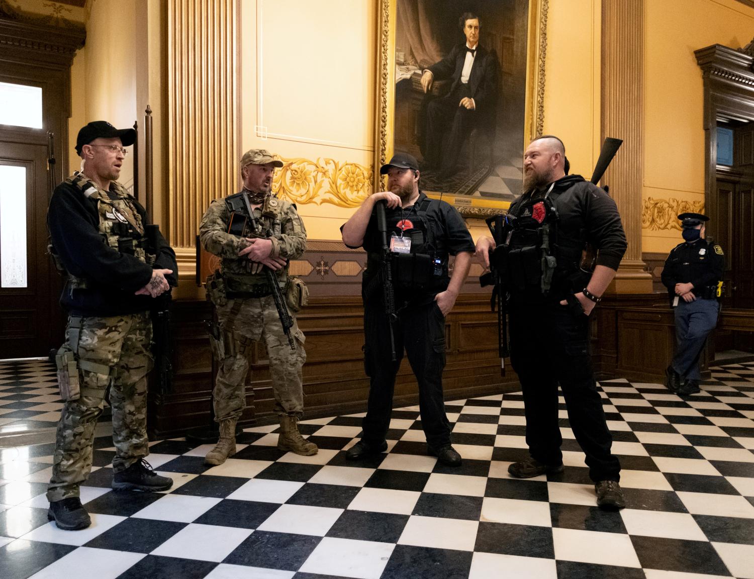 FILE PHOTO: Members of a militia group, including Michael John Null and Willam Grant Null (R) who were charged October 8, 2020 for their involvement in a plot to kidnap the Michigan governor, attack the state capitol building and incite violence, stand near the doors to the chamber in the capitol building before the vote on the extension of Governor Gretchen Whitmer's emergency declaration/stay-at-home order due to the coronavirus disease (COVID-19) outbreak, in Lansing, Michigan, U.S. April 30, 2020.  REUTERS/Seth Herald/File Photo