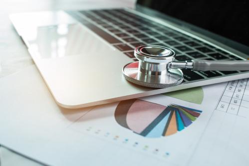 Laptop with stethoscope and and pie chart.