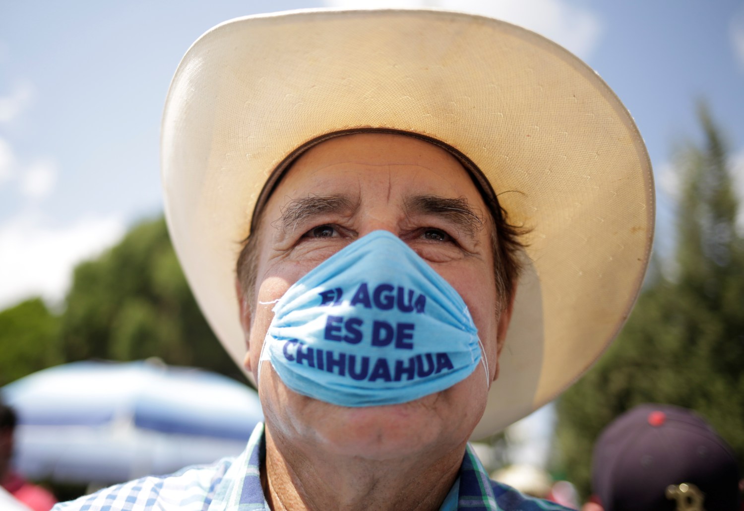 A man wearing a protective face mask attends a protest against the decision of the Mexican government to divert water from La Boquilla dam to the U.S., as part of a 1944 bilateral water treaty between the two countries, in Delicias, Chihuahua state, Mexico September 20, 2020. The writing reads, "Water belongs to Chihuahua". REUTERS/Jose Luis Gonzalez