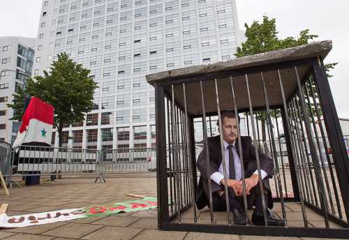 A man wearing a mask of Syrian President Bashar al-Assad demonstrates against Assad in front of the International Criminal Court (ICC) offices in The Hague June 7, 2011. REUTERS/Michael Kooren  (NETHERLANDS - Tags: POLITICS CIVIL UNREST IMAGES OF THE DAY)