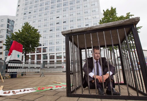 A man wearing a mask of Syrian President Bashar al-Assad demonstrates against Assad in front of the International Criminal Court (ICC) offices in The Hague June 7, 2011. REUTERS/Michael Kooren  (NETHERLANDS - Tags: POLITICS CIVIL UNREST IMAGES OF THE DAY)