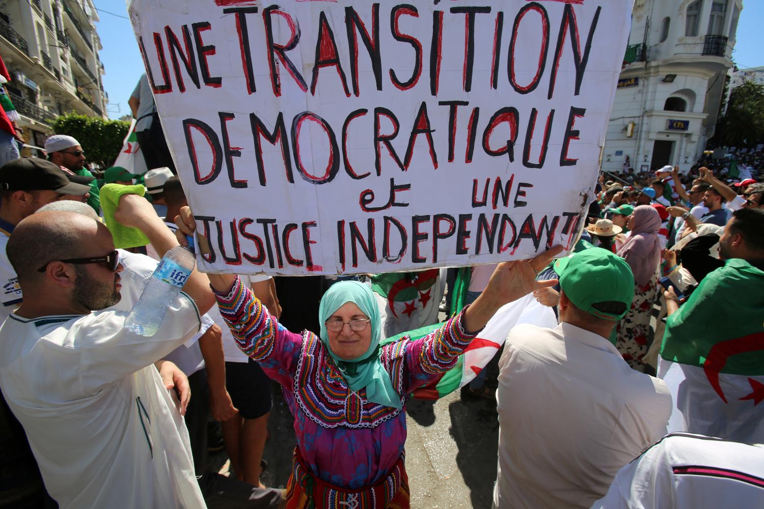 A demonstrator holds up a sign during a protest demanding the removal of the ruling elite in Algiers, Algeria June 28, 2019. The sign reads: " A democratic transition and an independent justice".  REUTERS/Ramzi Boudina