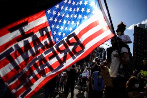 A child sits on her father's shoulders as he carries a U.S. flag during a protest against racial inequality in the aftermath of the death in Minneapolis police custody of George Floyd, in front of the at Grand Army Plaza in the Brooklyn borough of New York City, New York, U.S. June 7, 2020. REUTERS/Eduardo Munoz     TPX IMAGES OF THE DAY