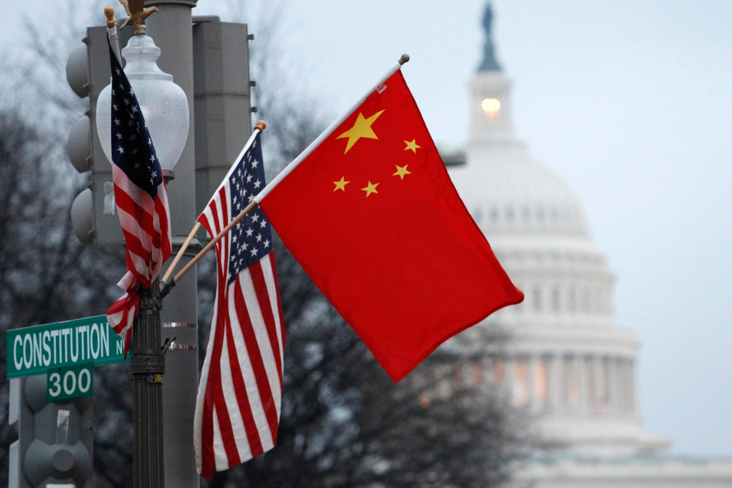 The People's Republic of China flag and the U.S. Stars and Stripes fly on a lamp post along Pennsylvania Avenue near the U.S. Capitol in Washington during Chinese President Hu Jintao's state visit, January 18, 2011. Hu arrived in the United States on Tuesday for a state visit with U.S. President Barack Obama that is aimed at strengthening ties between the world's two biggest economies. REUTERS/Hyungwon Kang (UNITED STATES - Tags: POLITICS CITYSCAPE) - GM1E71J0K0R01