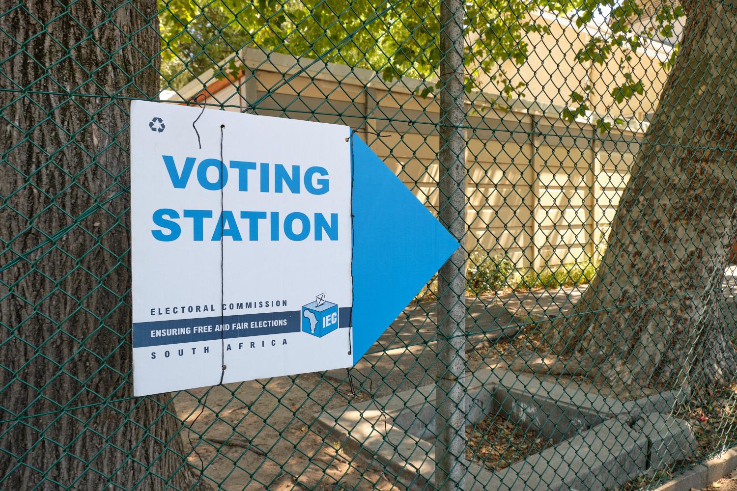 South African election voting station sign from the electoral commission, with the polling station in background. Cape Town, South Africa - Circa 2019
