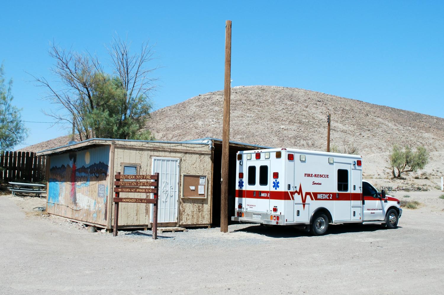Ambulance in front of a small building.