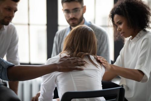 Woman being comforted by a support group.