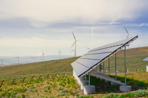 Solar panel and row of wind turbines under cloud blue sky at Ellensburg, Washington, US.