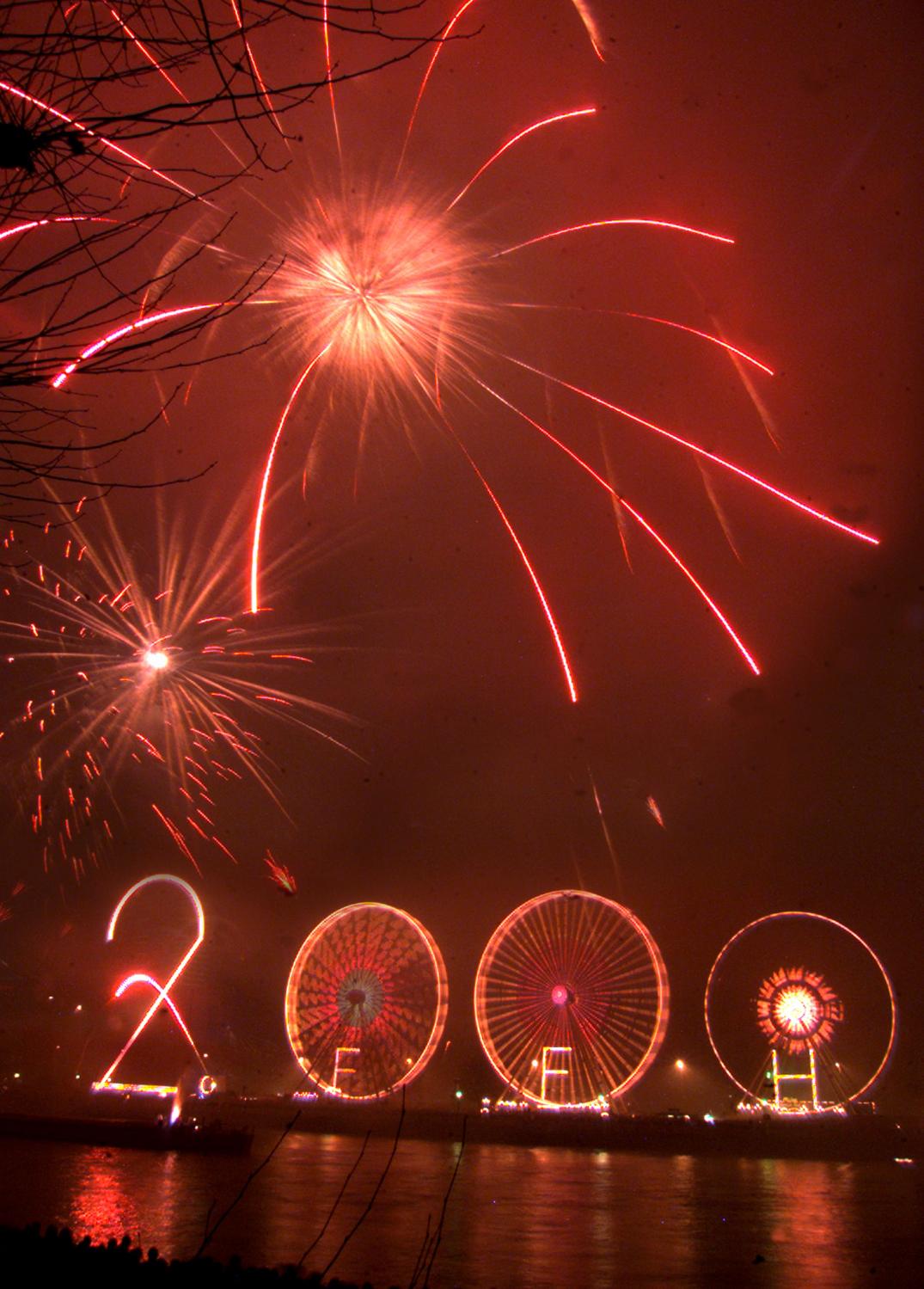 Fireworks illuminates the cloudy sky over a large 2000 built up with three Ferris wheels and a 40 meter tall number two at the bank of the river Main in Frankfurt, January 1. Some hundred thousands revelers are expected to celebrate the year 2000 in downtown Frankfurt.KP