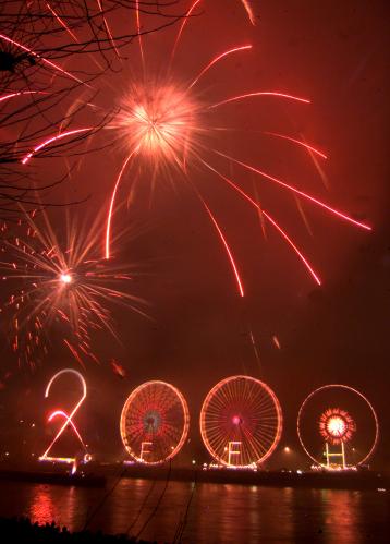 Fireworks illuminates the cloudy sky over a large 2000 built up with three Ferris wheels and a 40 meter tall number two at the bank of the river Main in Frankfurt, January 1. Some hundred thousands revelers are expected to celebrate the year 2000 in downtown Frankfurt.KP