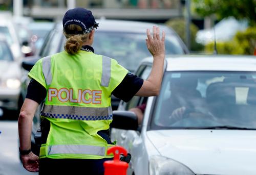 A police officer stops a driver at a checkpoint at Coolangatta on the Queensland - New South Wales border, Thursday, April 9, 2020. The Queensland Government  is introducing new border control measures effective Friday where Queenslander residents crossing the border back into Queensland will also now need a permit.  (AAP Image/Dave Hunt) NO ARCHIVINGNo Use Australia. No Use New Zealand.