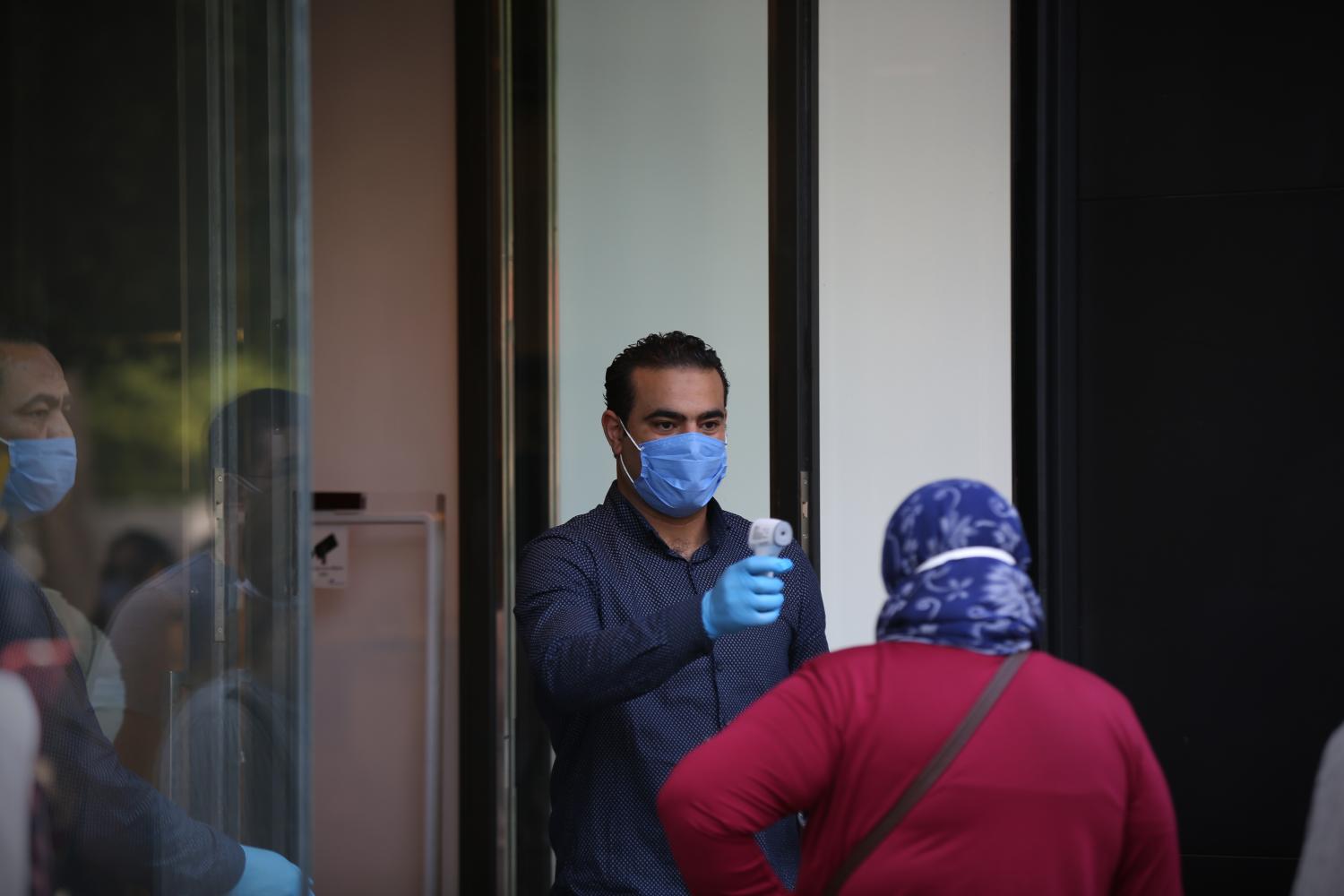 Shop agent mesure temperature of the client before entring during the first opning of the shops after the lockdown in Tunis, Tunisia on May 11, 2020. With the health ban in its first phase (from 4 to 24 May) entering its second week, the commercial movement in the capital resumed its activity in a significant and significant way by recovering the activity of selling ready-made clothes and shoes and the rest of the other commercial activities. Since the early hours of Monday morning, most shops selling ready-made clothes and shoes have opened their doors to the public amid strict precautions to prevent the spread of the new Coronavirus (COVID-19), despite Tunisia's relative control of this global pandemic. (Photo by Mohamed Krit/ Sipa USA)No Use UK. No Use Germany.