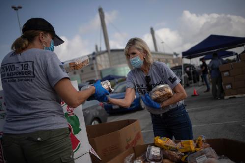 Volunteers Shirley Wood and Cindy Trevino grab bread and pastries to give to residents, affected by the economic fallout caused by the coronavirus disease (COVID-19) pandemic, during a San Antonio Food Bank distribution in San Antonio, Texas, U.S., July 17, 2020. REUTERS/Adrees Latif