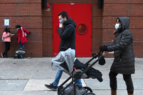 People walk past the entrance of PS 234 Independence School as elementary schools to reopen, New York, NY, December 7, 2020. New York City Mayor Bill de Blasio announced that public pre-K and elementary schools can return to in-person learning on Dec. 7., while middle and high schools remain closed; Schools were closed on Nov. 18 when the city surpassed the 3% infection rate threshold set by the Mayor de Blasio. (Photo by Anthony Behar/Sipa USA)No Use UK. No Use Germany.