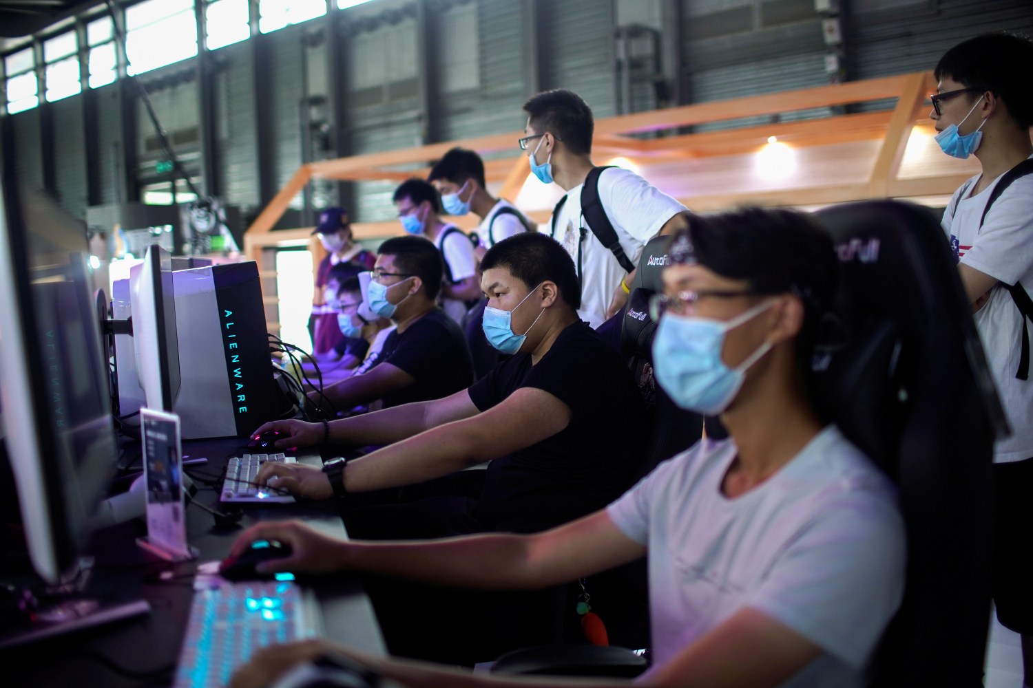 People wearing protective face masks play computer games at the China Digital Entertainment Expo and Conference (ChinaJoy) in Shanghai, following the coronavirus disease (COVID-19) outbreak, China July 31, 2020. REUTERS/Aly Song