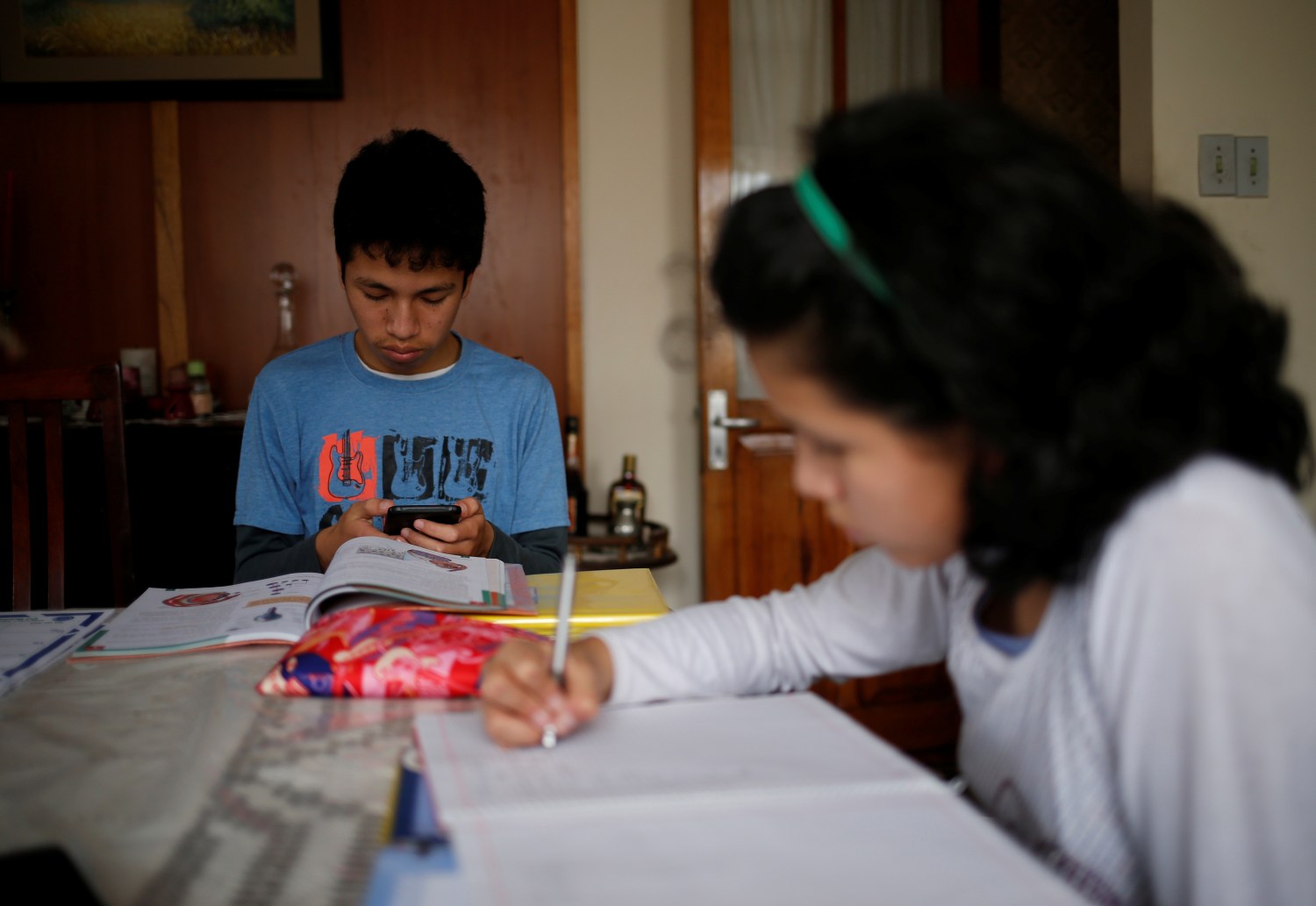 Sebastian Berrios and her sister Maria Fernanda study at home using electronic devices, as the country is under a nationwide quarantine to contain the coronovirus disease (COVID-19), in La Paz, Bolivia April 1, 2020. REUTERS/David Mercado