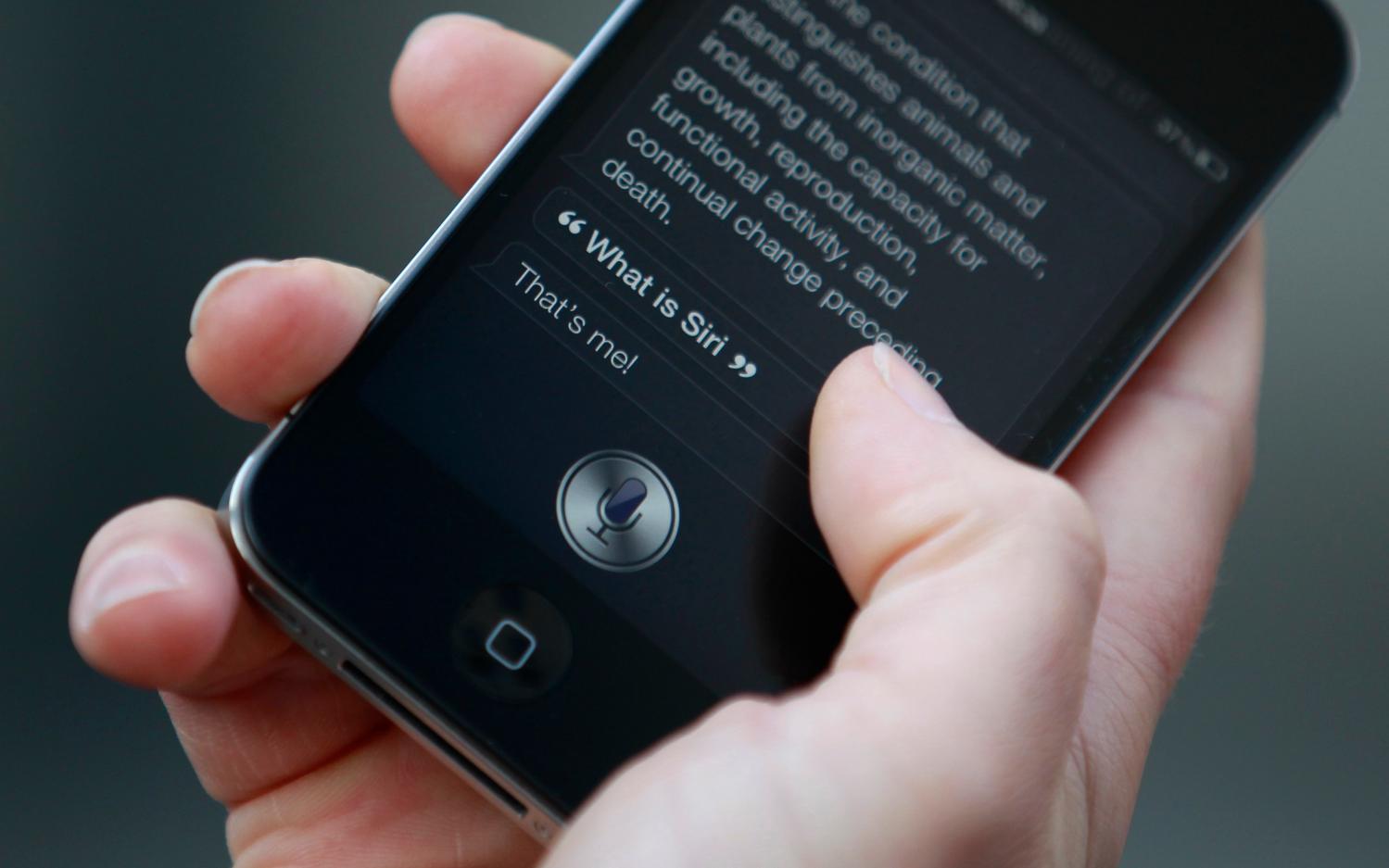 Luke Peters demonstrates Siri, an application which uses voice recognition and detection on the iPhone 4S, outside the Apple store in Covent Garden, London  October 14, 2011. REUTERS/Suzanne Plunkett (BRITAIN - Tags: BUSINESS SOCIETY SCIENCE TECHNOLOGY TELECOMS)