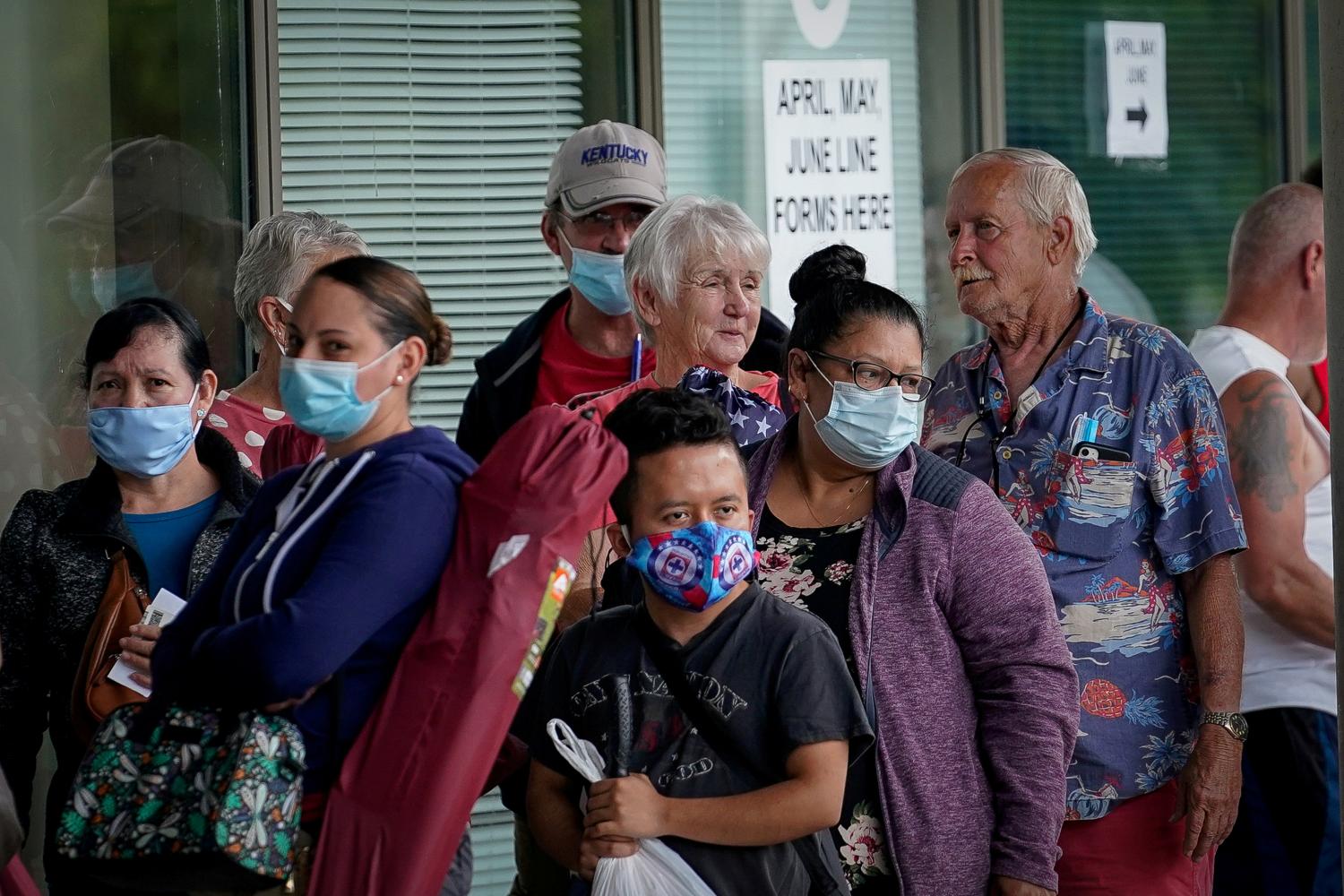 FILE PHOTO: People line up outside a Kentucky Career Center hoping to find assistance with their unemployment claim in Frankfort, Kentucky, U.S. June 18, 2020. REUTERS/Bryan Woolston/File Photo/File Photo