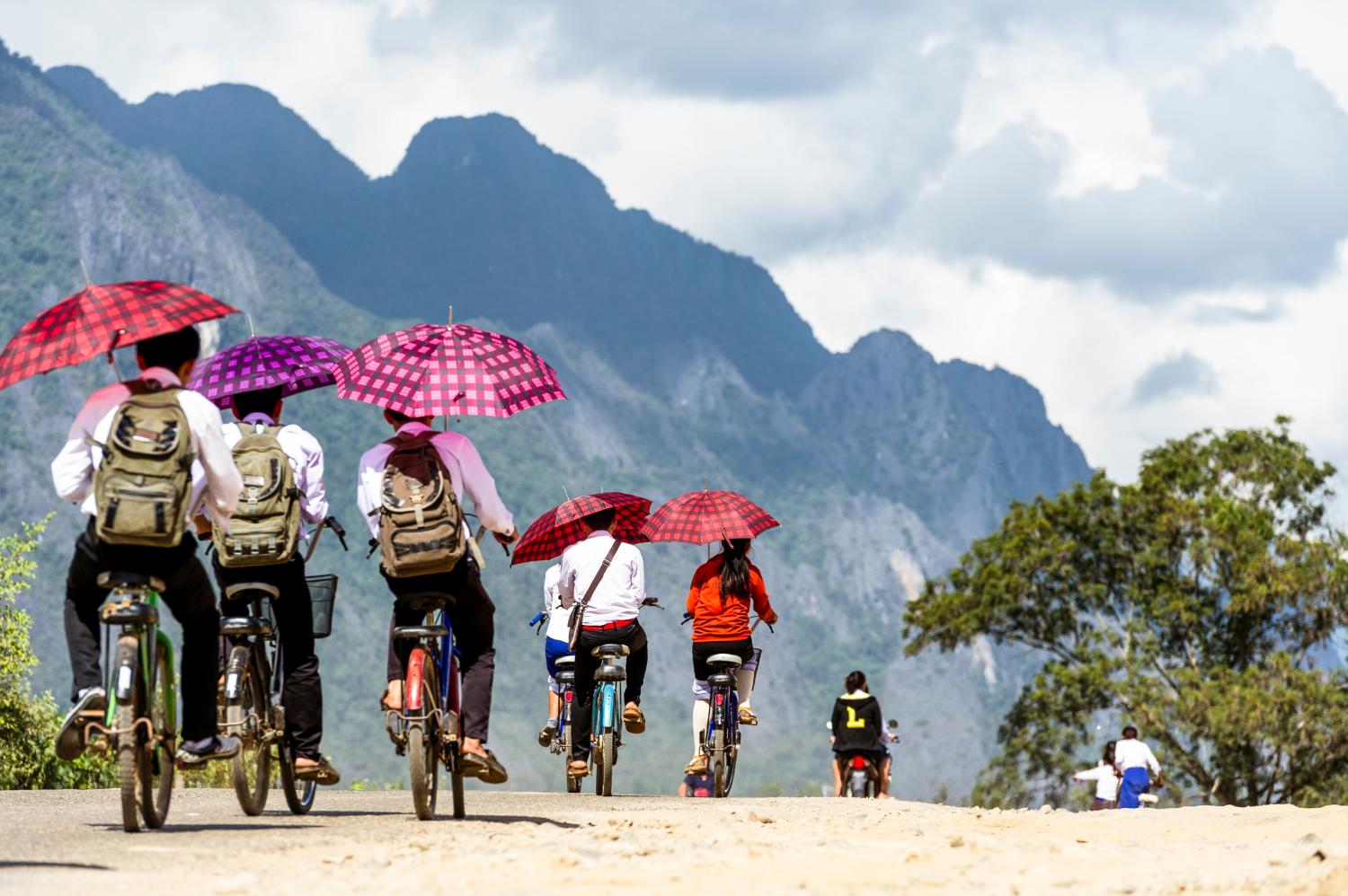 Vang Vieng. Laos. 15/12/2017. Children leaving school by bicycle