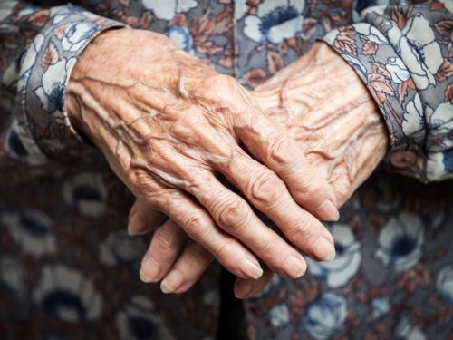 Elderly woman with hands crossed