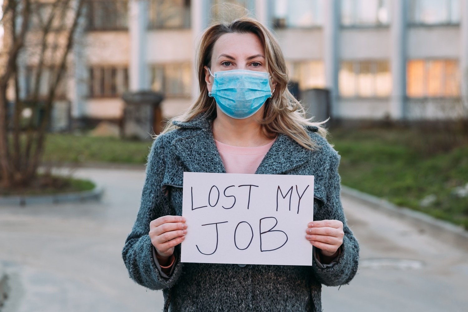 stock image of women holding sign that says, "Lost My Job"
