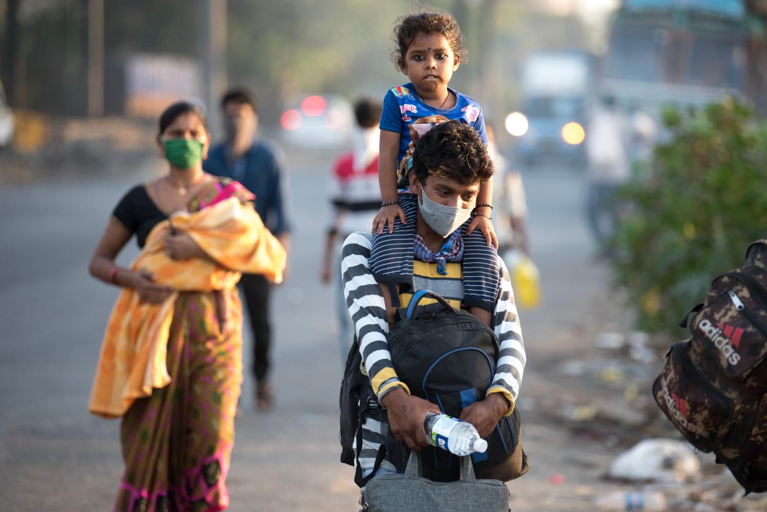 MUMBAI/INDIA - MAY 11, 2020: Migrant workers walk on the highway on their journey back home during a nationwide lockdown to fight the spread of the COVID-19 coronavirus.