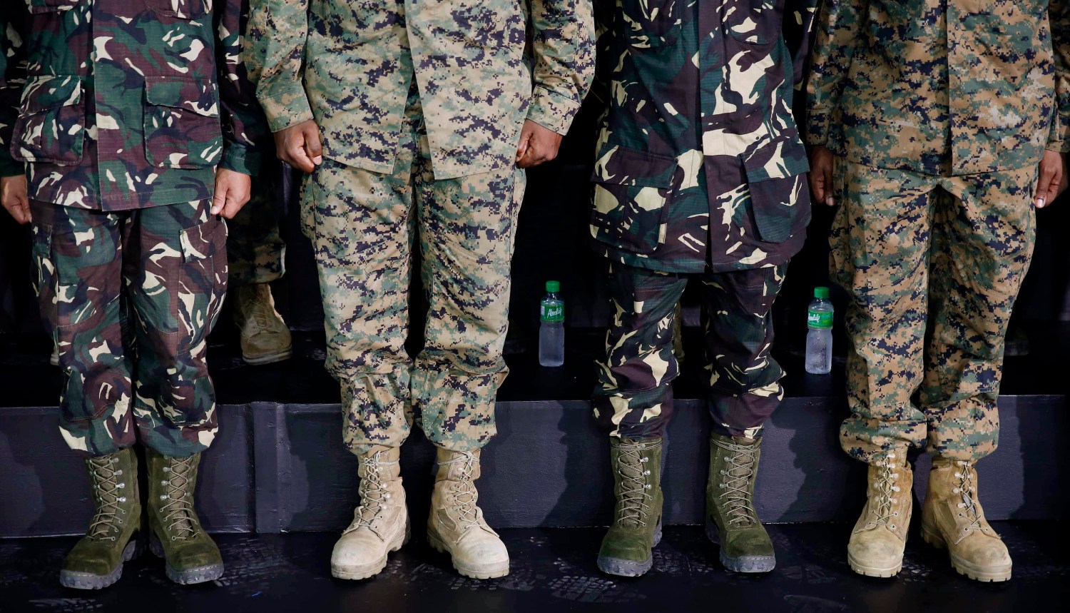 The various boots worn by multi-nation troops are seen as the soldiers listen to U.S. President Barack Obama speak to military troops at the Fort Bonifacio Gymnasium in Manila, April 29, 2014. REUTERS/Larry Downing (PHILIPPINES - Tags: POLITICS)