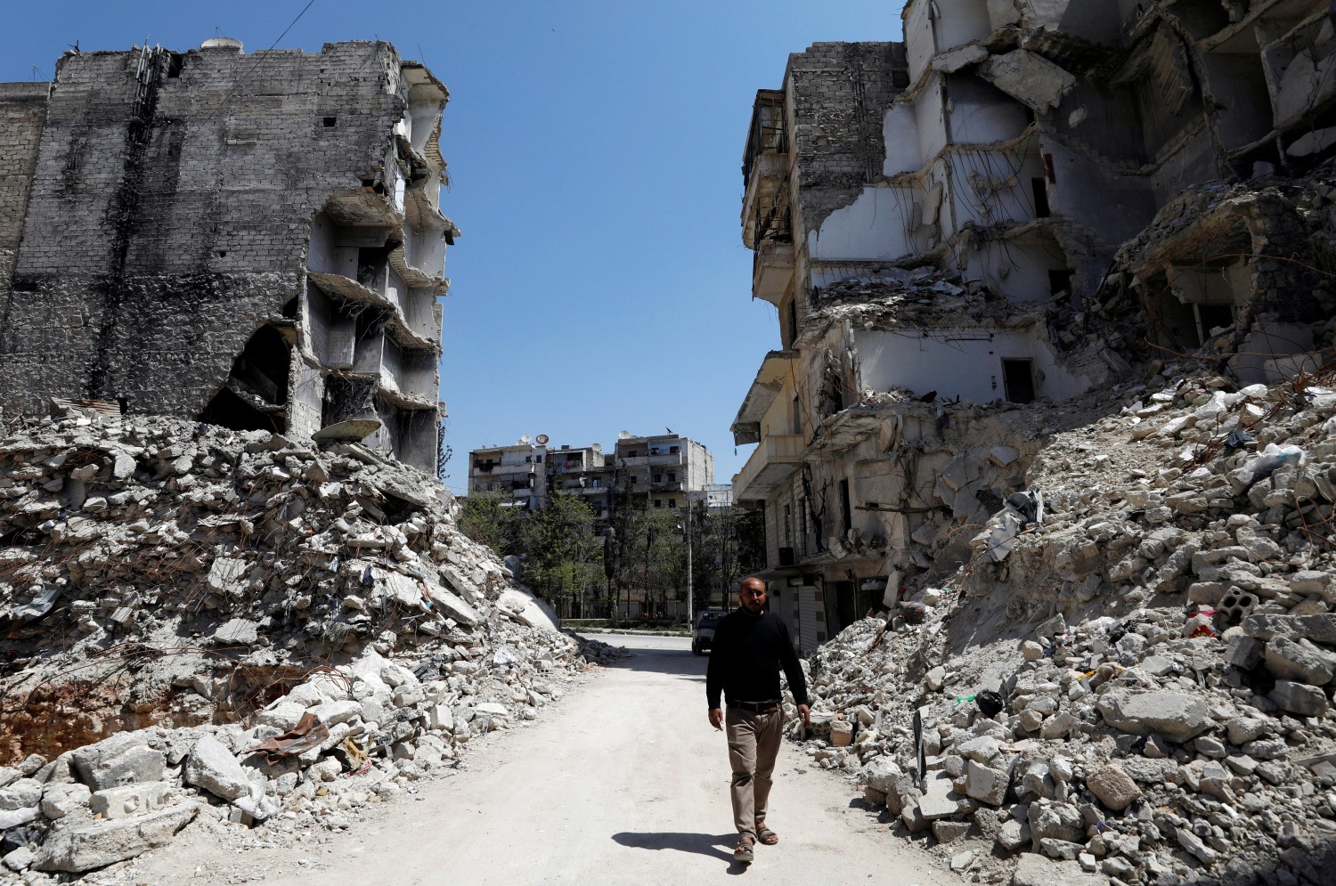 Abu hassan, a local man, walks past rubble in Aleppo's Salaheddine district, Syria April 13, 2019. Picture taken April 13, 2019. REUTERS/Omar Sanadiki