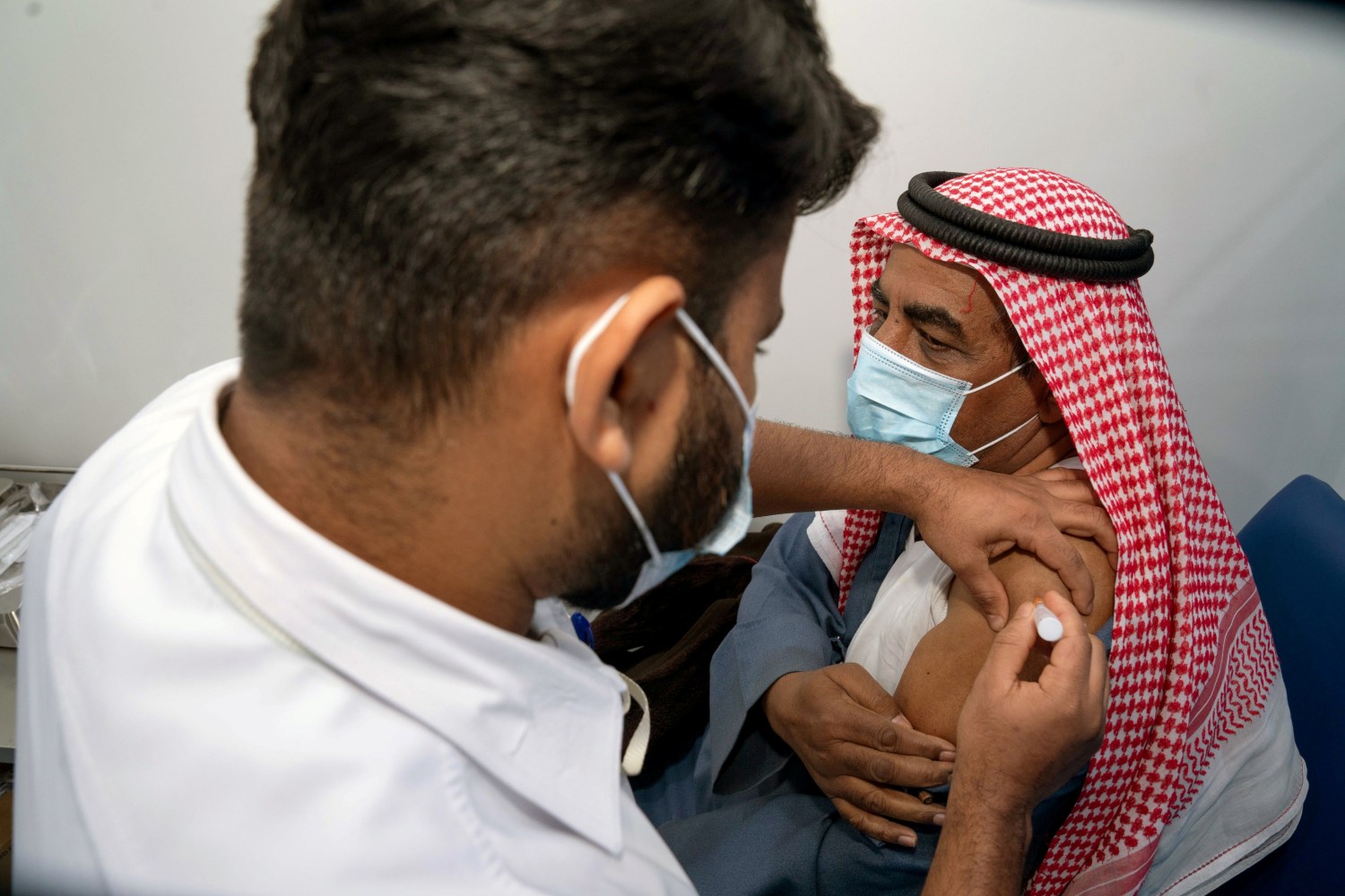 A Kuwaiti man, Abdulla al Anazi, gets a dose of a coronavirus disease (COVID-19) vaccine in Kuwait City, Kuwait December 24, 2020. REUTERS/Stephanie McGehee