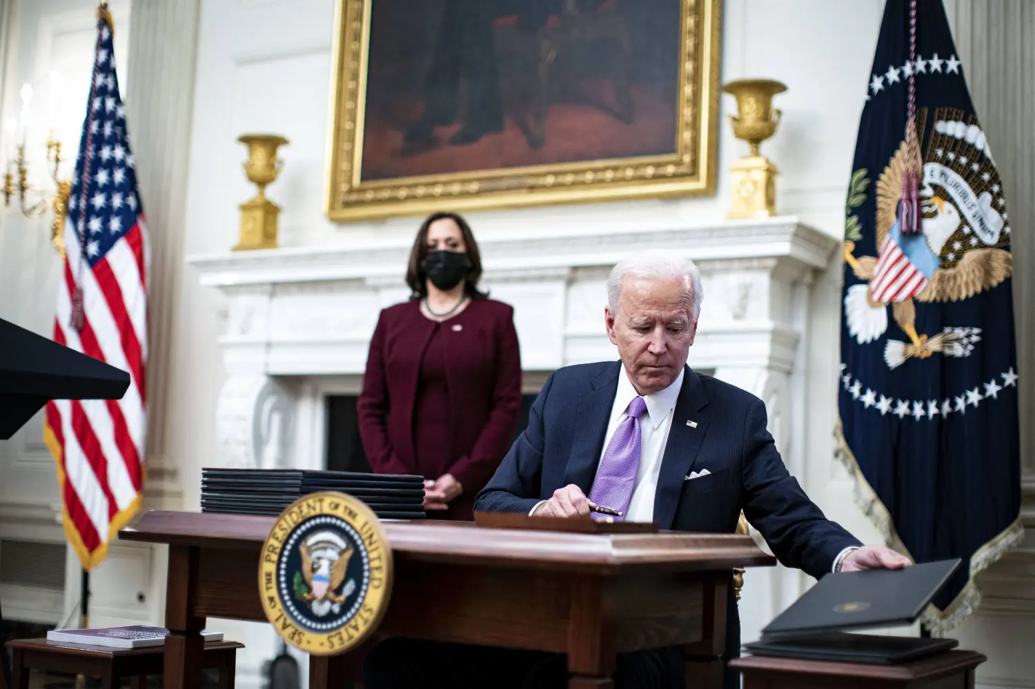 U.S. President Joe Biden signs an executive order after speaking during an event on his administration's Covid-19 response with U.S. Vice President Kamala Harris, left, in the State Dining Room of the White House in Washington, D.C., U.S., on Thursday, Jan. 21, 2021. Biden in his first full day in office plans to issue a sweeping set of executive orders to tackle the raging Covid-19 pandemic that will rapidly reverse or refashion many of his predecessor's most heavily criticized policies. Photo by Al Drago/Pool/ABACAPRESS.COM