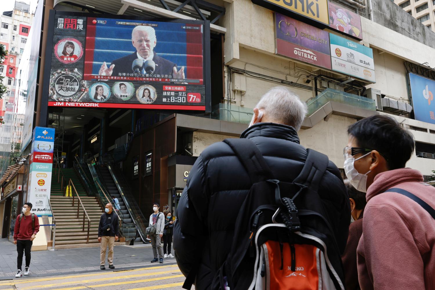 People look at a TV screen showing news of U.S. President Joe Biden after his inauguration, in Hong Kong, China January 21, 2021. REUTERS/Tyrone Siu