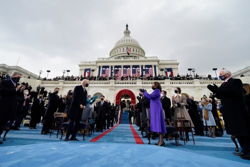 US Vice President-elect Kamala Harris (2nd R) applauds as President-elect Joe Biden arrives for his Inauguration as the 46th President of the United States, at the US Capitol.