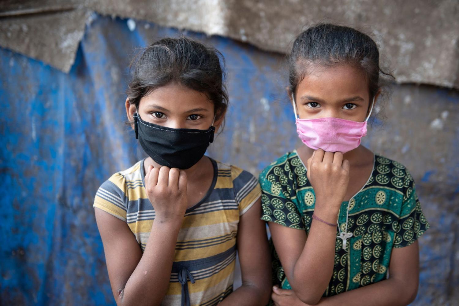 Two girls wear masks.