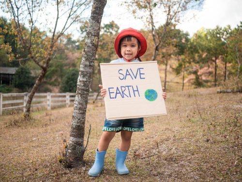 Young girl holding a "save earth" sign