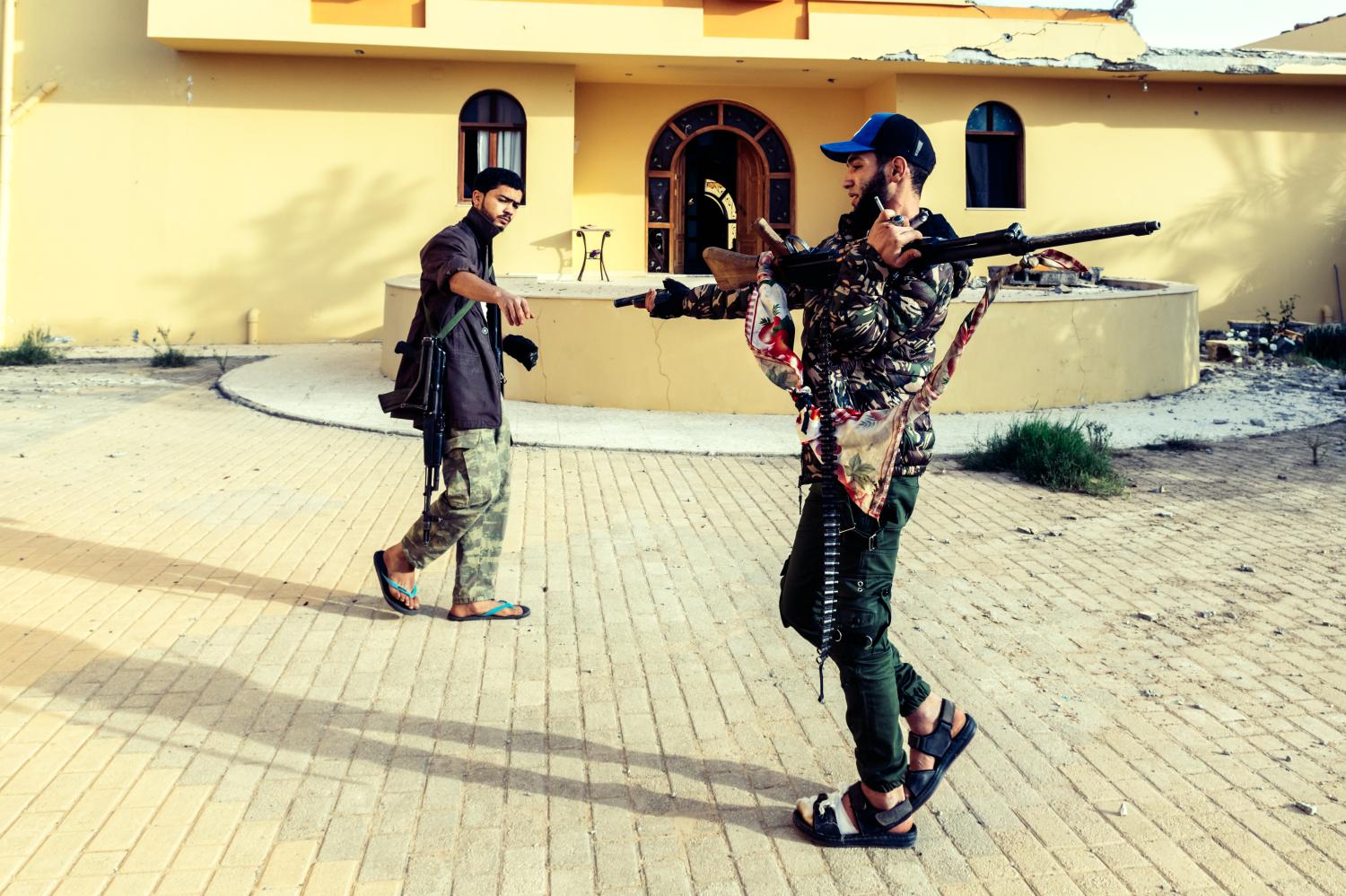 On the front line of Al Swani during the battle, two fighters of the 610 Brigade (GNA) are passing a revolver from hand to hand. Since April, the Libyan National Army (LNA) led by Khalifa Haftar is attempting to take control of Tripoli defended by the forces of UN-backed recognised Government of National Accord of Fayez el-Sarraj (GNA). Libya, outskirts of Tripoli, December 6, 2019.Sur la ligne de front de Al Swani pendant les combats, deux combattants de la brigade 610 (GAN) se passe un revolver de la main a la main. Depuis avril, l'armee nationale Libyenne (LNA) dirigee par Khalifa Haftar essaie de prendre le control de Tripoli defendu par les forces du gouvernement d'accord national de Fayez al-Sarraj, soutenu par l'onu (GAN). Libye, banlieue de Tripoli, 6 decembre 2019.NO USE FRANCE