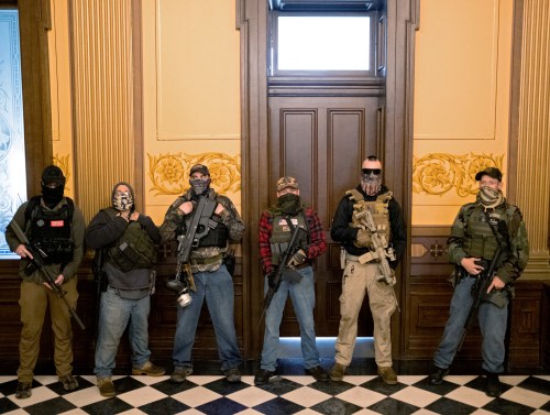 FILE PHOTO: A militia group with no political affiliation from Michigan, including Joseph Morrison (3rd R), Paul Bellar (2nd R) and Pete Musico (R) who were charged for their involvement in a plot to kidnap Michigan Governor Gretchen Whitmer, attack the state capitol building and incite violence, stand in front of the governor's office after protesters occupied the state capitol building during a vote to approve the extension of Whitmer's emergency declaration/stay-at-home order due to the coronavirus disease (COVID-19) outbreak, in Lansing, Michigan, U.S. April 30, 2020. REUTERS/Seth Herald/File Photo   SEARCH "AMERICA IN THE AGE OF TRUMP" FOR THE PHOTOS.