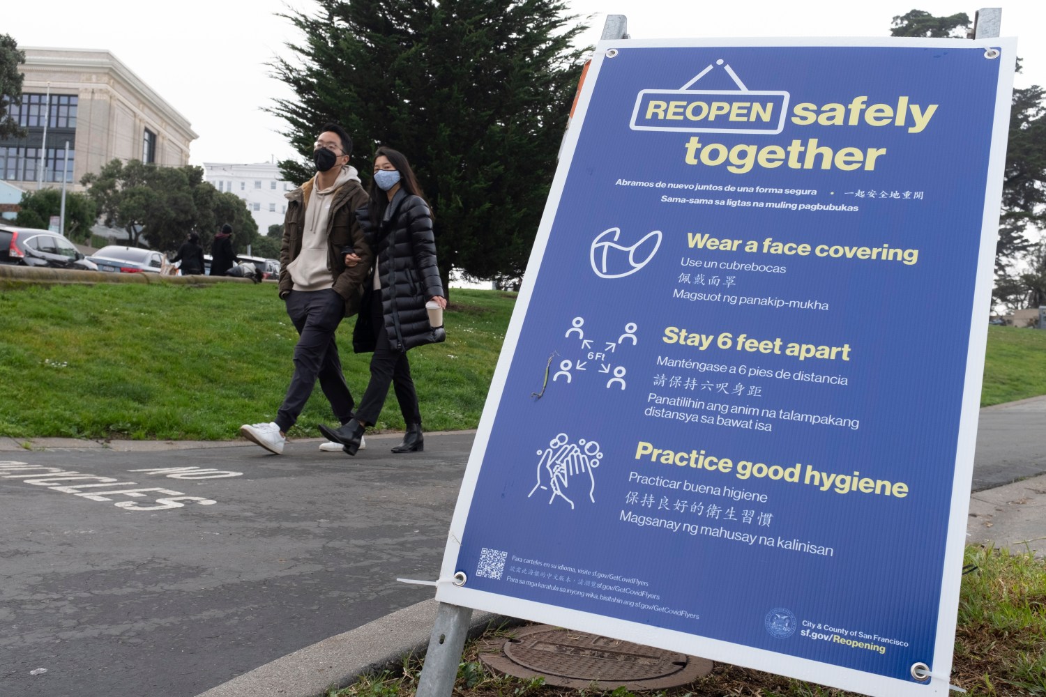 People walk past a sign while wearing masks to prevent contracting and spreading novel coronavirus in San Francisco, California, United States on January 3, 2021. California has implemented shelter-in-place order to encourage people to stay home during the winter holiday to counter the surge of the coronavirus (COVID-19) cases in the global pandemic. U.S. confirmed cases has surpassed 20 millions on the first day of 2021. (Photo by Yichuan Cao/Sipa USA)No Use UK. No Use Germany.