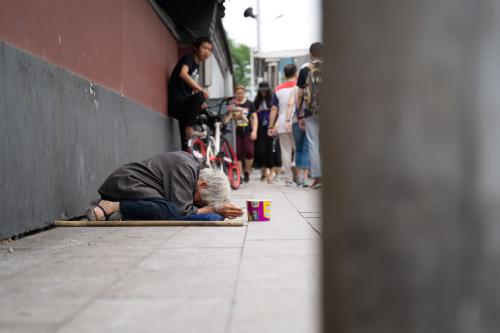 Yonghe Temple, Beijing, China, Jun 17,2018: Old female beggar on the street was asking some money from tourists who passing by.