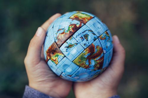 Hands holding a a globe like a Rubik's cube