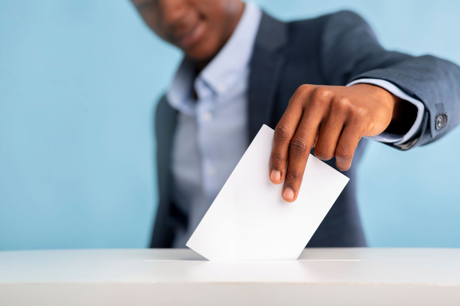 Man placing ballot in ballot box