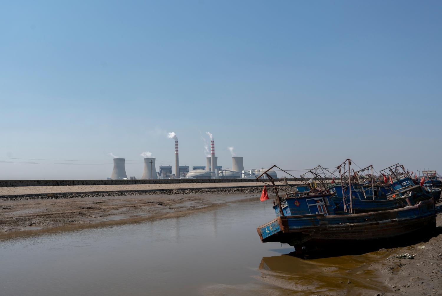 Tianjin/China-April 12,2020:Smoking chimneys of a power plant, located beside a fishing village.