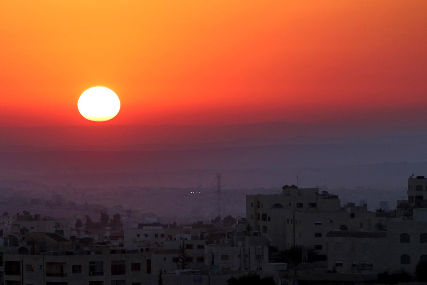 The sun rises on the first day of Eid al-Fitr in Amman August 19, 2012. Eid-al-Fitr marks the end of Ramadan, the holiest month on the Islamic calendar.  REUTERS/Muhammad Hamed (JORDAN - Tags: CITYSPACE ENVIRONMENT RELIGION)