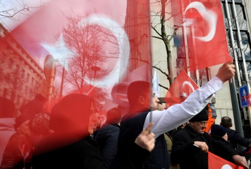 Supporters of Turkish President Tayyip Erdogan wave national flags ahead of a meeting of the president with NATO Secretary General Jens Stoltenberg, in Brussels, Belgium March 9, 2020. REUTERS/Johanna Geron