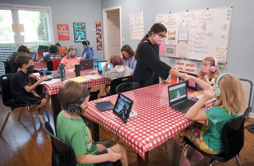 Teaching assistant Maggie Morreale helps a student during online learning in a room turned into a school at the Franklin home of certified teacher Jessica Morreale on Tuesday, Aug. 18, 2020. The Learning Cottage offers support for remote learning for 10 students.Remotelearning 01