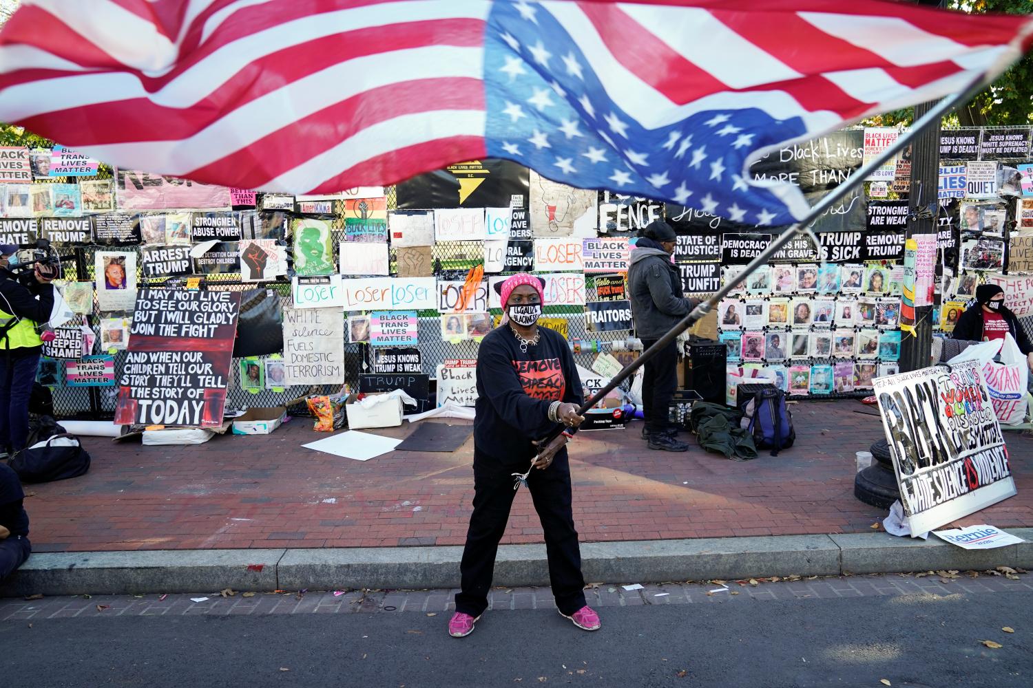 Nadine Seiler from Waldorf, Maryland, waves an upside-down American flag outside the White House the day after the 2020 U.S. presidential election in Washington, U.S., November 4, 2020. REUTERS/Erin Scott